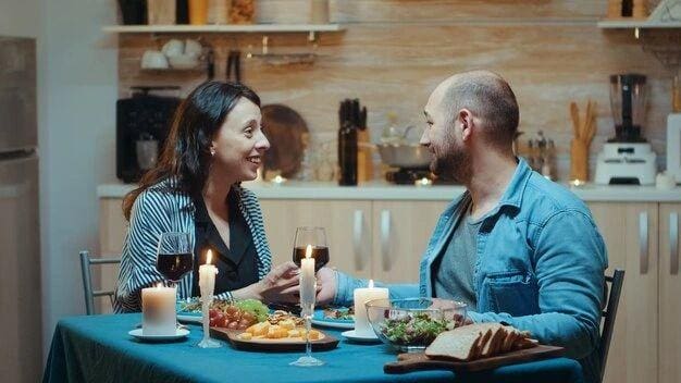 A man and woman sitting at the table with food.