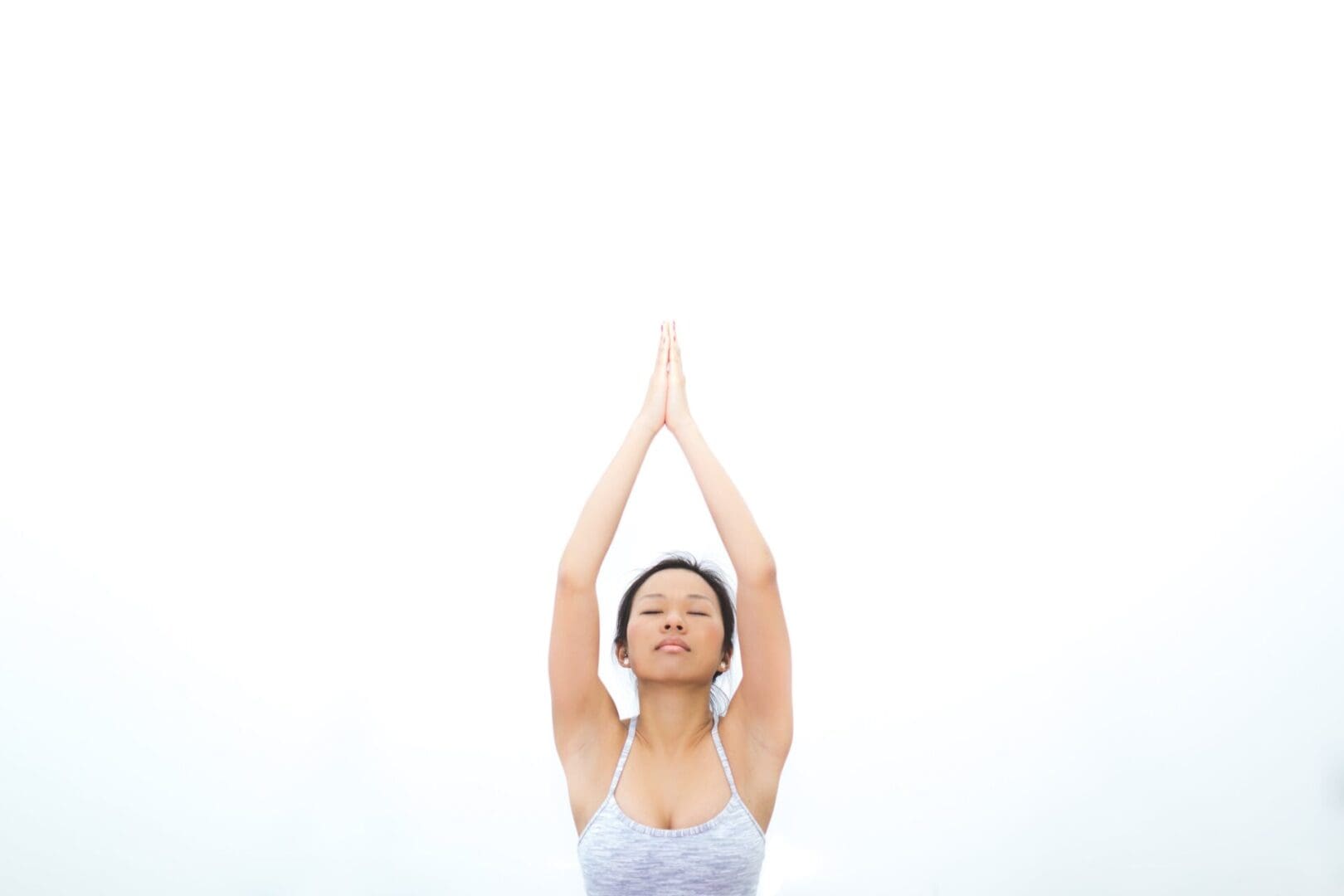 A woman in white shirt doing yoga on top of her head.