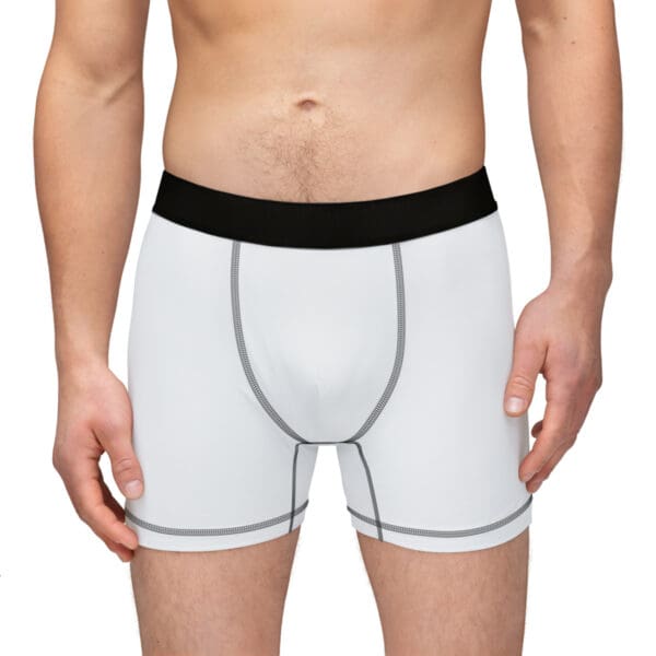 A man wearing white underwear with black trim.