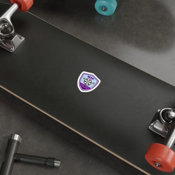 A skateboard with a purple sticker on it