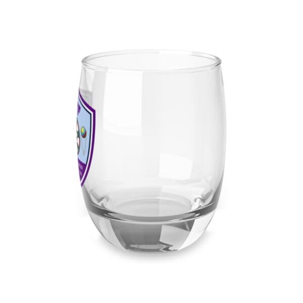 A glass with a purple and blue shield on it.