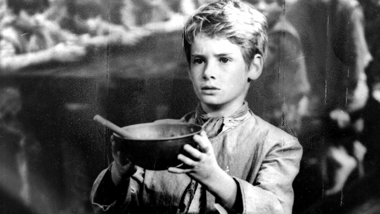 A young boy holding a bowl of food.