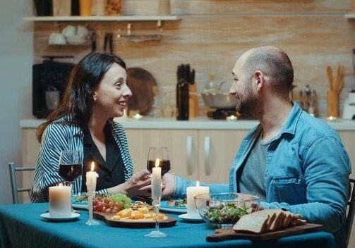 A man and woman sitting at the table with food.