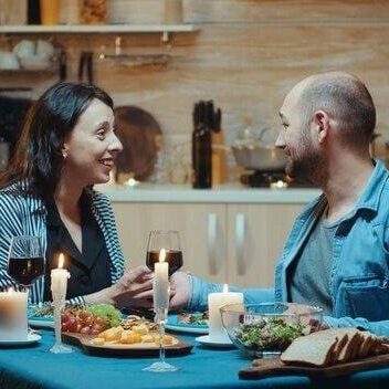 A man and woman sitting at the table with food.