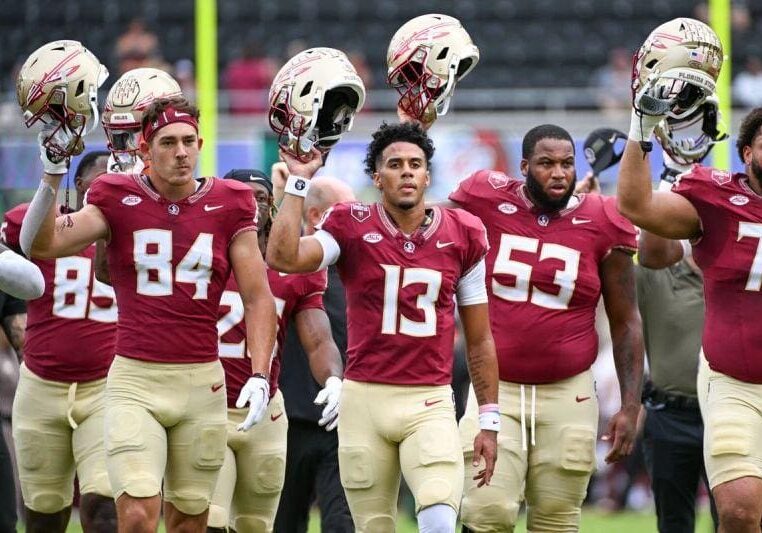 A group of football players walking on the field