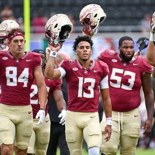 A group of football players walking on the field