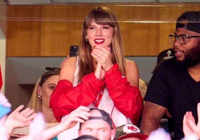 A woman in red jacket sitting on top of a chair.