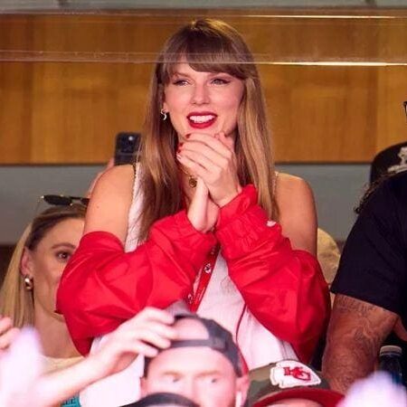 A woman in red jacket sitting on top of a chair.