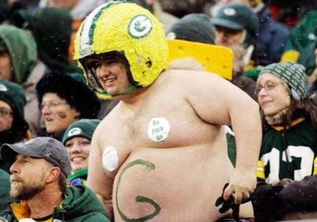 A man in green bay packers gear is standing up.
