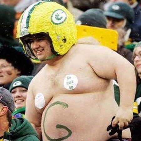 A man in green bay packers gear is standing up.